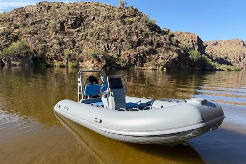 Slide: The Image of Custom grey and blue Catalina 13 boat by Tide Craft, 2027, on a serene lake. - 10