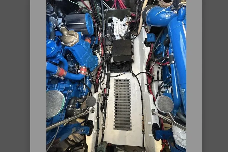 Slide: The Image of Engine room of a 1995 Tiara Yachts 4000 Express, showcasing dual blue engines and wiring. - 23