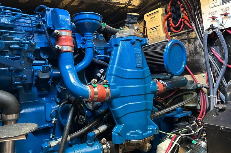 Slide: The Image of Engine compartment of a 1995 Tiara Yachts 4000 Express, showcasing blue machinery and wiring. - 26