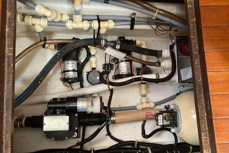 Slide: The Image of Engine compartment of a 1995 Tiara Yachts 4000 Express, showcasing pumps and plumbing. - 34