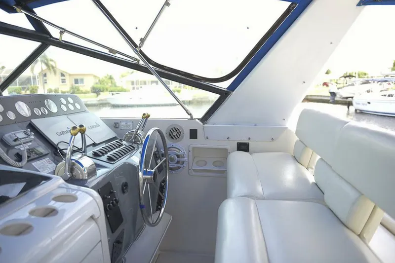 Slide: The Image of 1995 Tiara Yachts 4000 Express helm with steering wheel and navigation controls. - 4