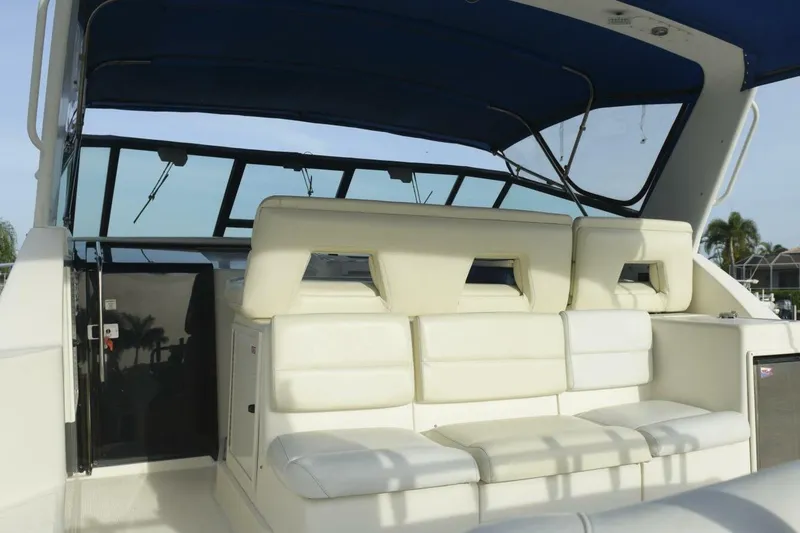 Slide: The Image of 1995 Tiara Yachts 4000 Express with white seating and blue canopy, showcasing luxury design. - 8