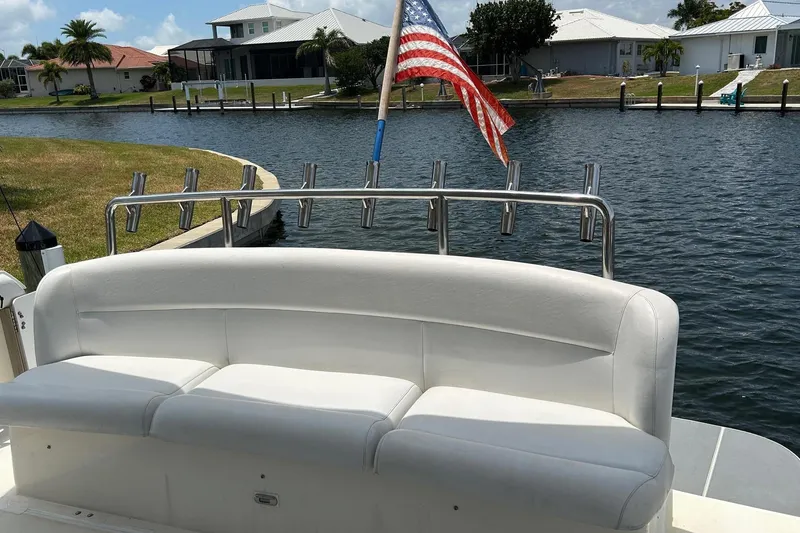 Slide: The Image of 1995 Tiara Yachts 4000 Express with white seating and American flag on a canal. - 9