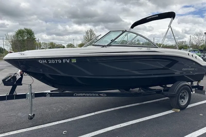 The Image of 2018 Chaparral 19 H2O Sport boat on trailer, parked outdoors under cloudy sky. - 1