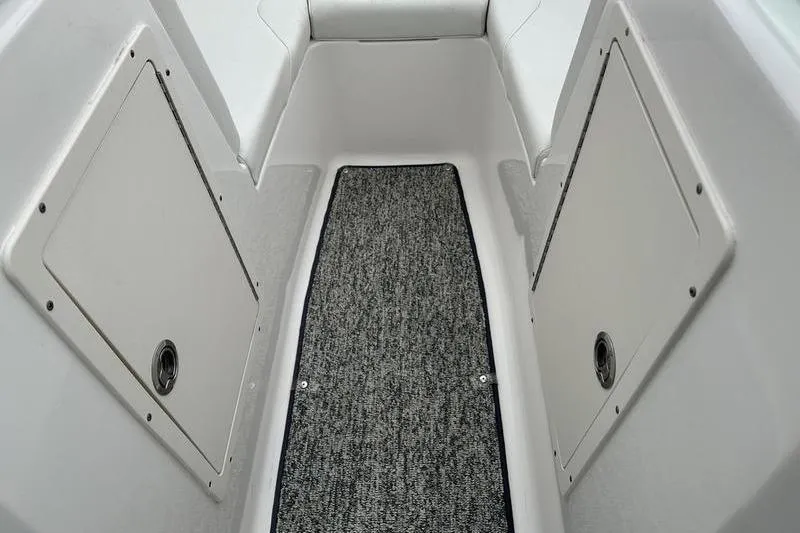 Slide: The Image of 2018 Chaparral 19 H2O Sport boat interior with carpeted flooring and storage compartments. - 10