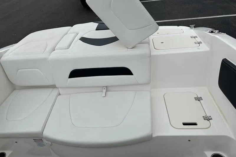 Slide: The Image of 2018 Chaparral 19 H2O Sport boat interior with white seating and storage compartments. - 11