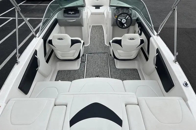 Slide: The Image of 2018 Chaparral 19 H2O Sport boat interior with white seating and steering console. - 16