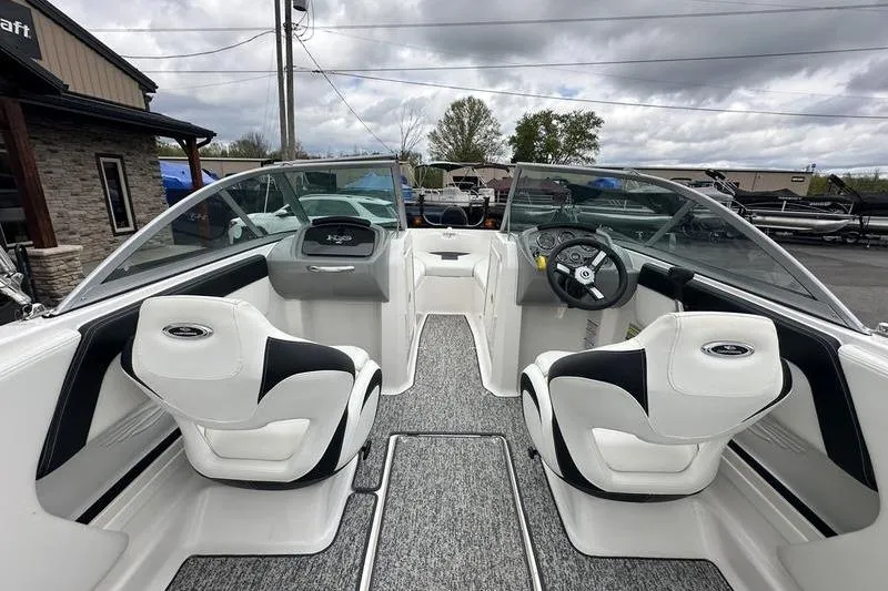 Slide: The Image of 2018 Chaparral 19 H2O Sport boat interior with dual seats and steering wheel. - 22