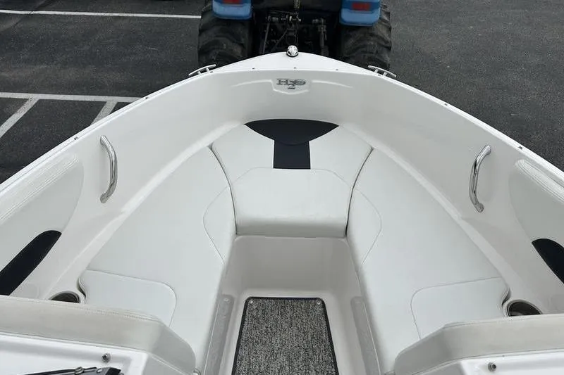 Slide: The Image of 2018 Chaparral 19 H2O Sport boat interior with white seating and carpeted floor. - 6