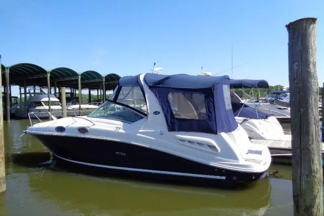 The Image of 2005 Sea Ray Sundancer 260 boat docked at marina under clear blue sky. - 0