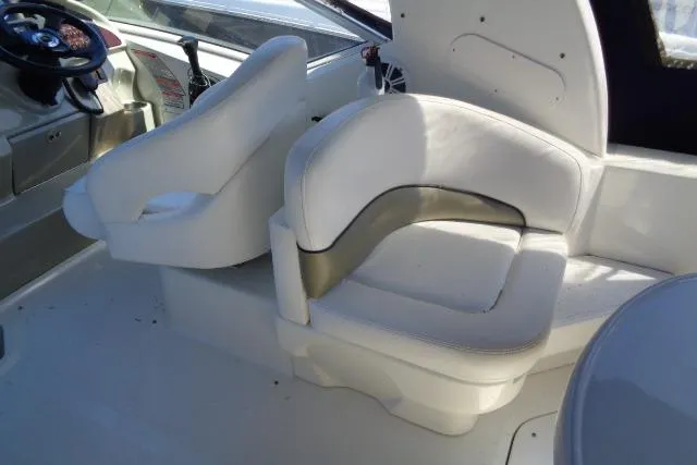 Slide: The Image of 2005 Sea Ray Sundancer 260 interior with white seating and helm area. - 10