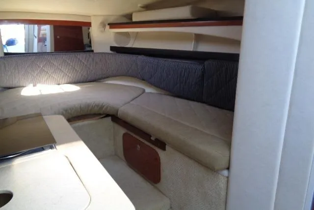 Slide: The Image of 2005 Sea Ray Sundancer 260 cabin interior with beige seating and striped cushions. - 14