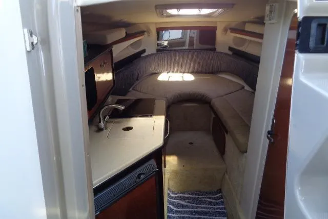 Slide: The Image of 2005 Sea Ray Sundancer 260 cabin interior with kitchenette and seating area. - 15