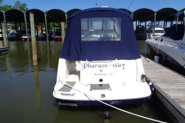 Slide: The Image of 2005 Sea Ray Sundancer 260 docked, rear view with blue canopy, named "Pharaon Way." - 4