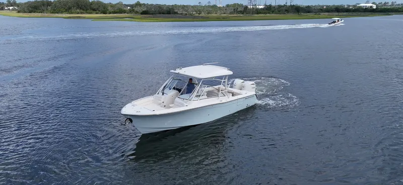 Slide: The Image of 2027 Grady-White Freedom 285 on calm water with another boat in the background. - 24