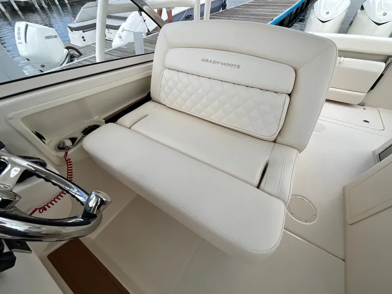 Slide: The Image of The image shows a luxurious white seat in the cockpit of a Grady-White Freedom 285 boat. - 20