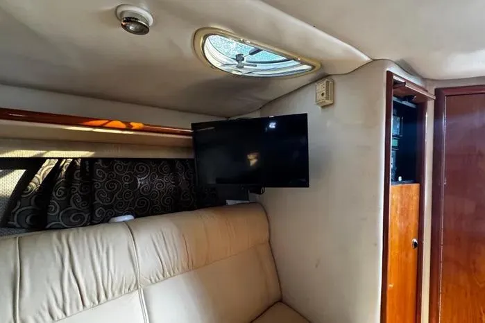 Slide: The Image of Interior of a 2005 Cobalt 360 Cruiser with TV and beige seating. - 13