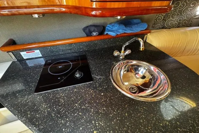 Slide: The Image of 2005 Cobalt 360 Cruiser interior with sleek countertop, sink, and stove. - 16