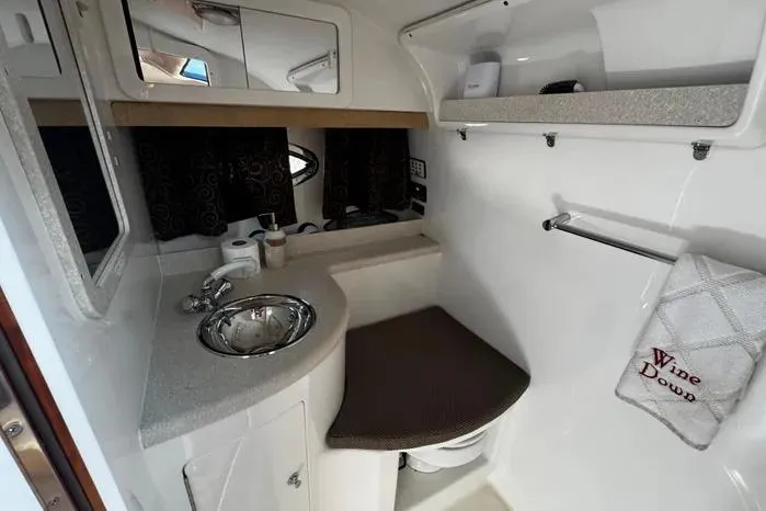 Slide: The Image of Compact bathroom interior of 2005 Cobalt 360 Cruiser with sink, mirror, and towel rack. - 18
