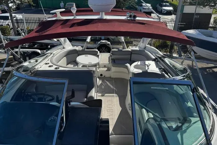 Slide: The Image of 2005 Cobalt 360 Cruiser with red canopy, spacious seating, and open deck layout. - 2