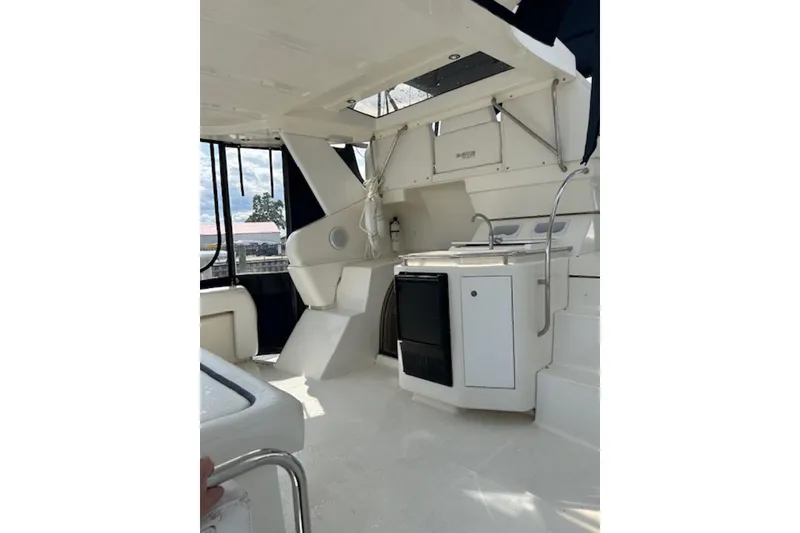 Slide: The Image of 1996 Silverton 442 Cockpit Motor Yacht interior with kitchenette and seating area. - 10