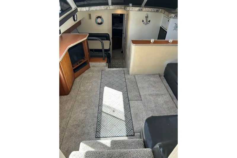 Slide: The Image of Interior of 1996 Silverton 442 Cockpit Motor Yacht with carpeted flooring and cozy seating area. - 13
