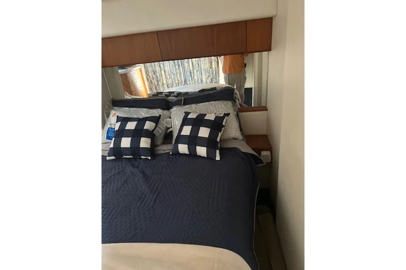 Slide: The Image of Interior of 1996 Silverton 442 Cockpit Motor Yacht bedroom with checkered pillows. - 18