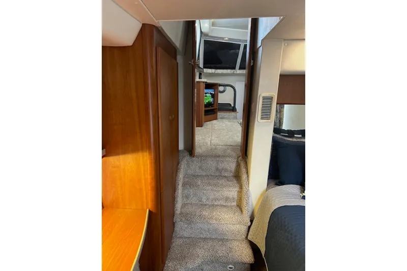Slide: The Image of Interior view of 1996 Silverton 442 Cockpit Motor Yacht with carpeted stairs and wooden cabinetry. - 19