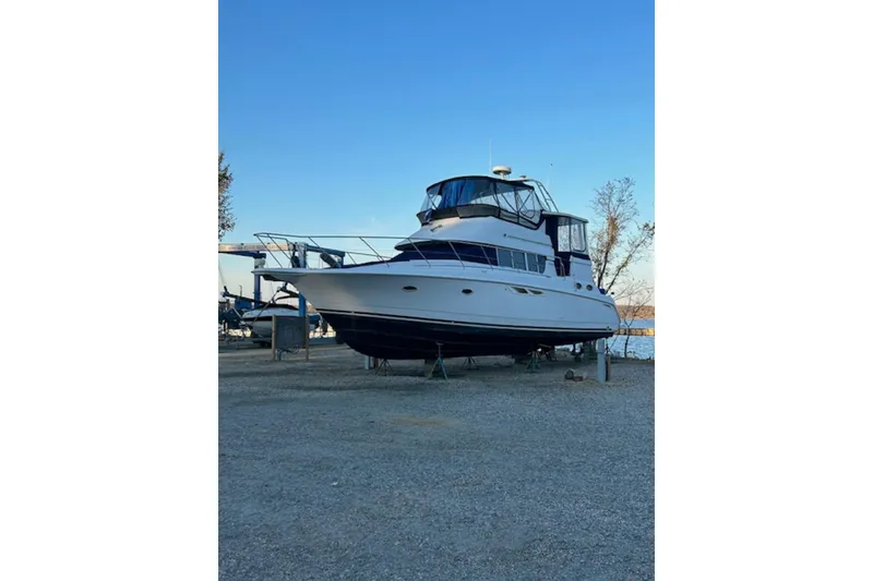Slide: The Image of 1996 Silverton 442 Cockpit Motor Yacht on dry dock, clear sky background. - 2