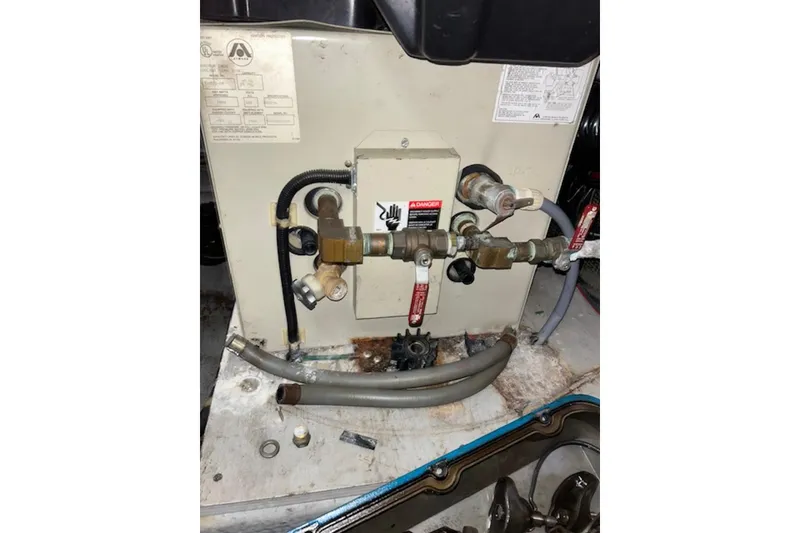 Slide: The Image of Engine compartment of a 1996 Silverton 442 Cockpit Motor Yacht, showing plumbing and valves. - 34