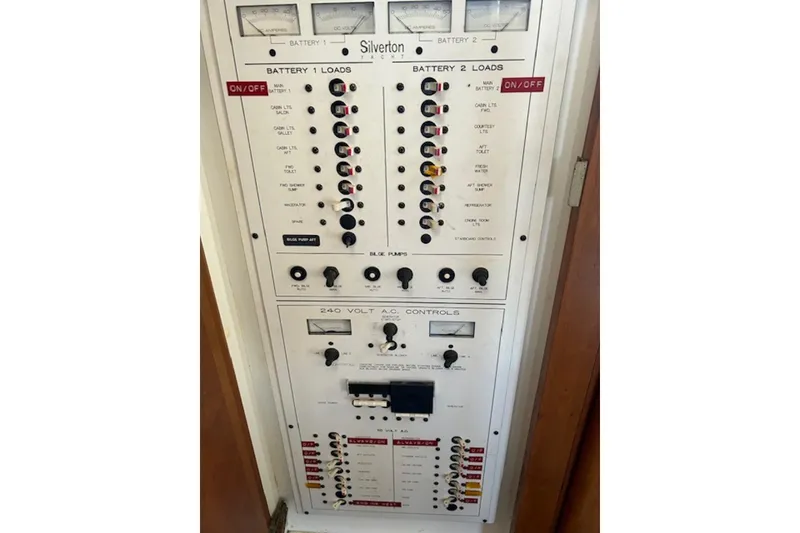 Slide: The Image of Electrical control panel of a 1996 Silverton 442 Cockpit Motor Yacht, featuring battery and AC controls. - 35