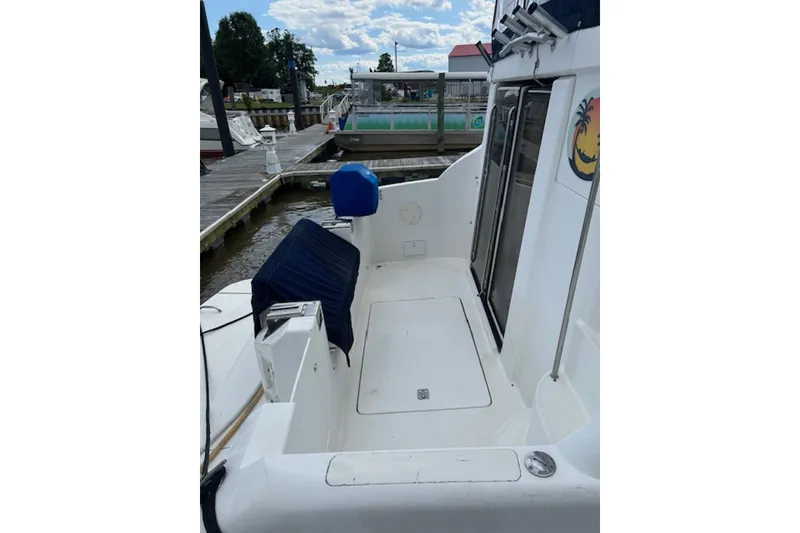 Slide: The Image of 1996 Silverton 442 Cockpit Motor Yacht docked, featuring spacious deck and seating area. - 5