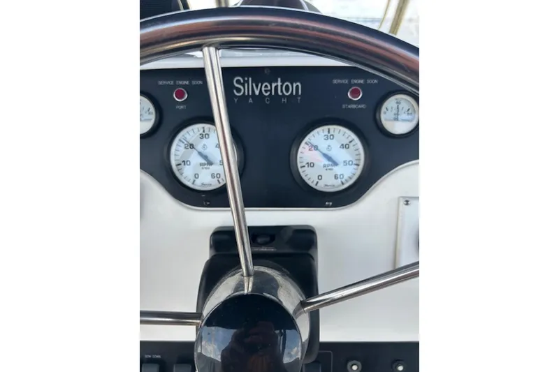 Slide: The Image of 1996 Silverton 442 Cockpit Motor Yacht dashboard with gauges and steering wheel. - 7
