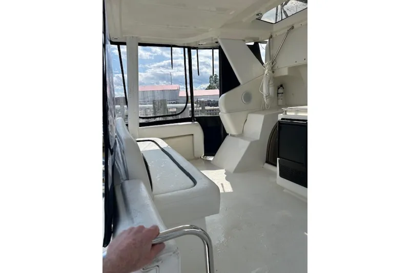 Slide: The Image of Interior view of 1996 Silverton 442 Cockpit Motor Yacht, featuring seating and windows. - 9