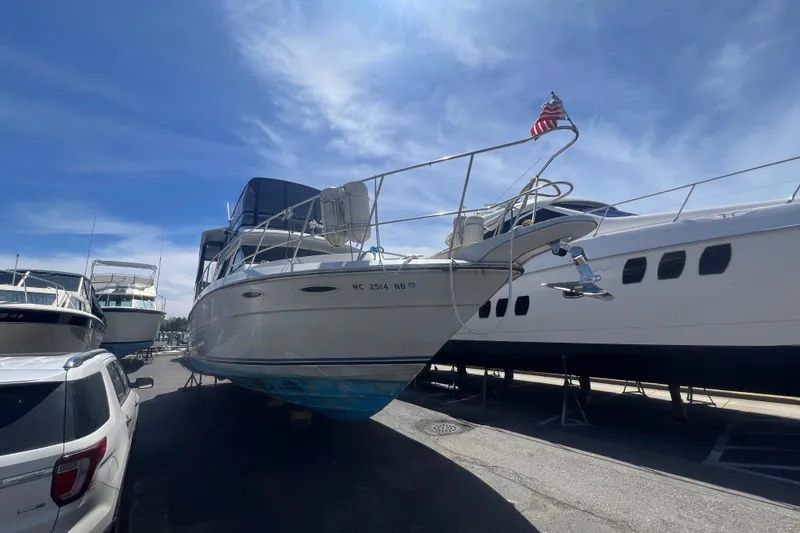 Slide: The Image of 1987 Sea Ray 410 Aft Cabin yacht on dry dock under a clear blue sky. - 1