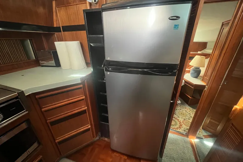 Slide: The Image of Kitchen area of 1987 Sea Ray 410 Aft Cabin with stainless steel refrigerator. - 14
