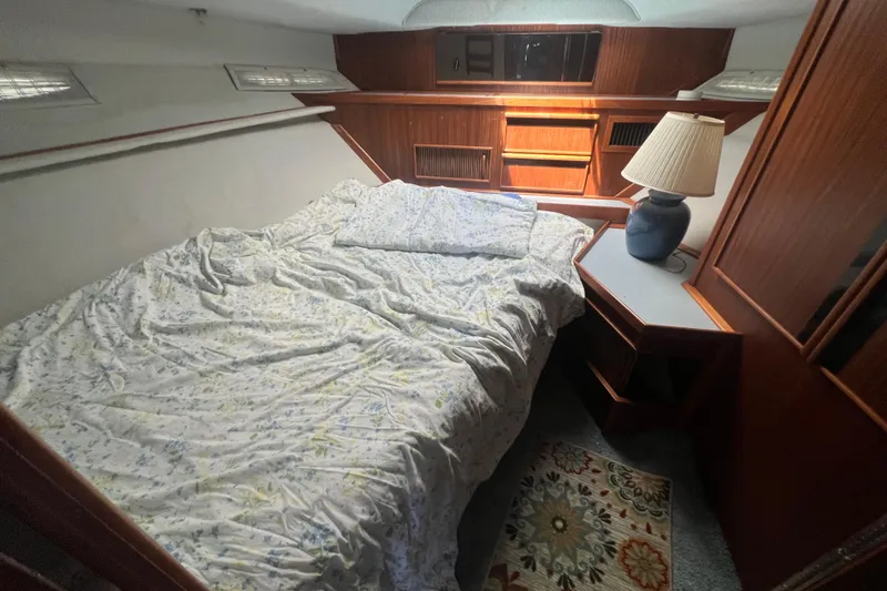 Slide: The Image of Cozy bedroom in 1987 Sea Ray 410 Aft Cabin with wooden cabinetry and floral bedding. - 16
