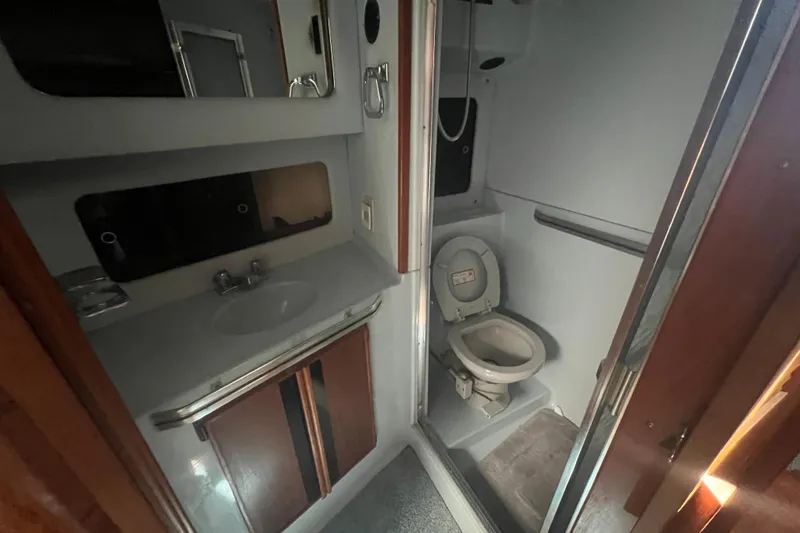 Slide: The Image of 1987 Sea Ray 410 Aft Cabin bathroom with sink, mirror, and toilet. - 17