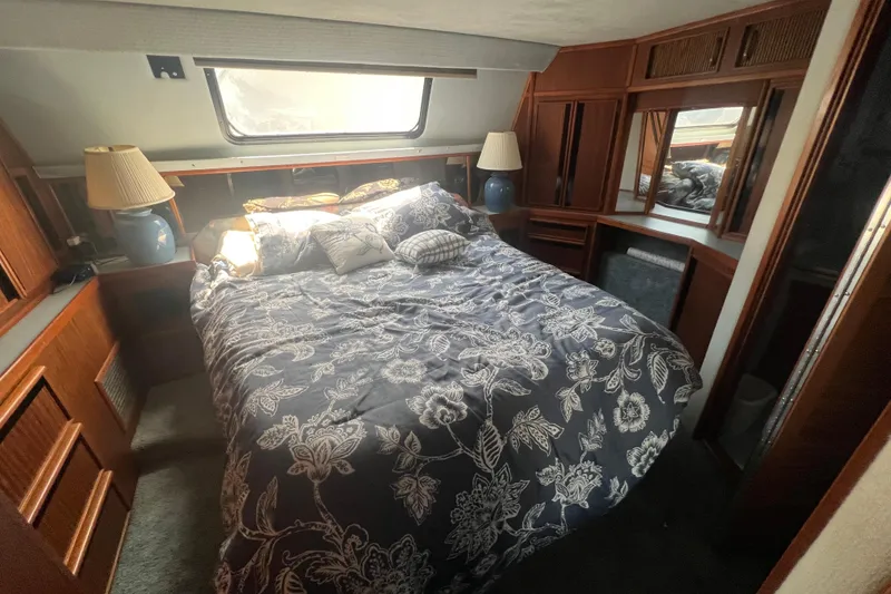 Slide: The Image of Cozy bedroom in 1987 Sea Ray 410 Aft Cabin with floral bedding and wooden accents. - 18