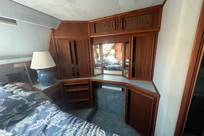 Slide: The Image of Interior of 1987 Sea Ray 410 Aft Cabin with wood cabinetry and a blue lamp. - 20