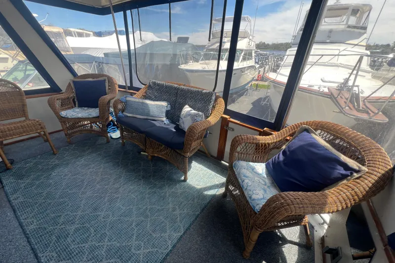 Slide: The Image of Cozy seating area on 1987 Sea Ray 410 Aft Cabin yacht with wicker furniture and cushions. - 4