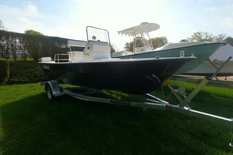 Slide: The Image of 2026 Maritime 189 Defiant boat on trailer, parked on grass under clear sky. - 16