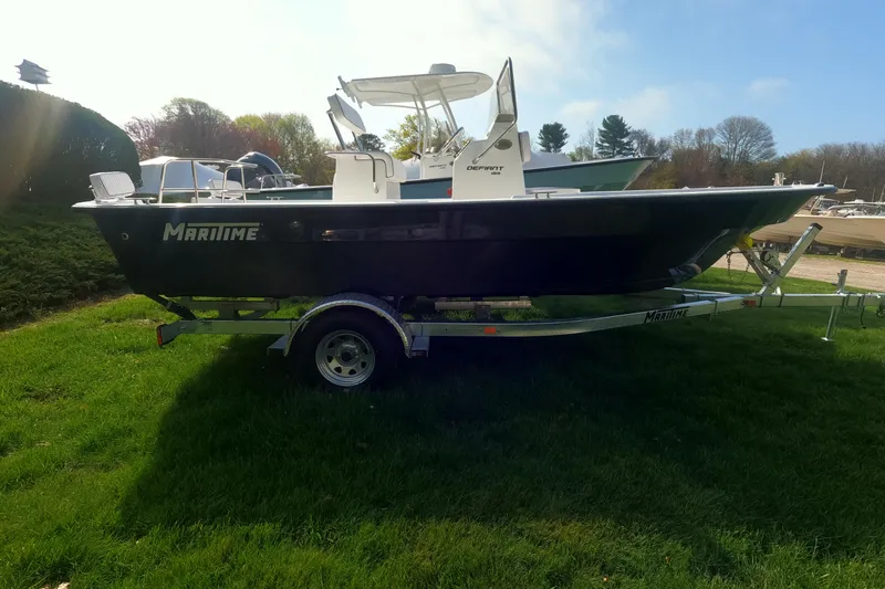 Slide: The Image of 2026 Maritime 189 Defiant boat on trailer, parked on grass under clear sky. - 17