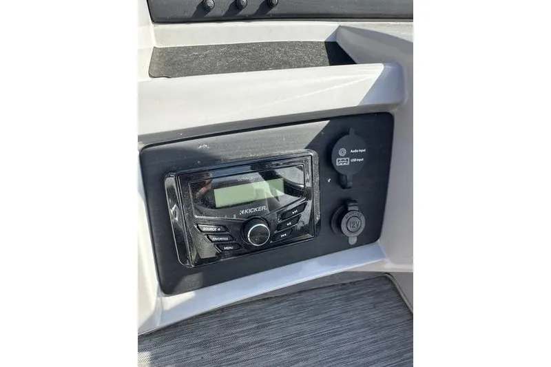 Slide: The Image of 2022 Bennington 22 L boat dashboard featuring Kicker audio system and input ports. - 10