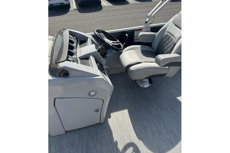 Slide: The Image of Captain's seat and helm of 2022 Bennington 22 L pontoon boat, featuring modern design. - 14