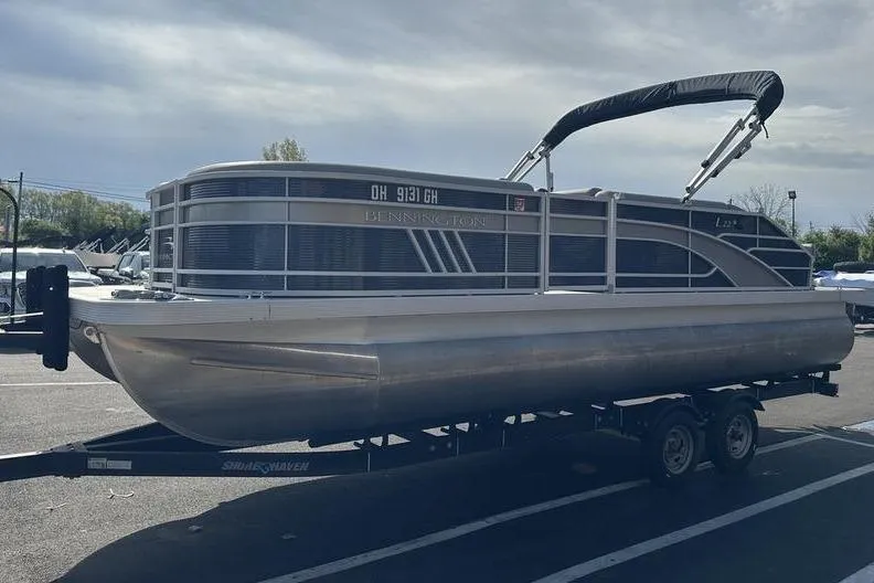 Slide: The Image of 2022 Bennington 22 L pontoon boat on trailer in parking lot. - 15