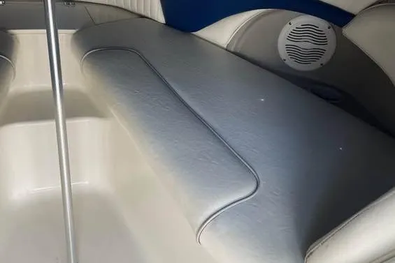 Slide: The Image of Interior seating of a 2006 Stingray 230 LX boat, featuring white upholstery and speaker. - 11