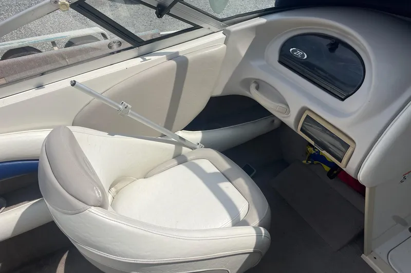 Slide: The Image of Interior of a 2006 Stingray 230 LX boat, featuring a white seat and dashboard. - 6
