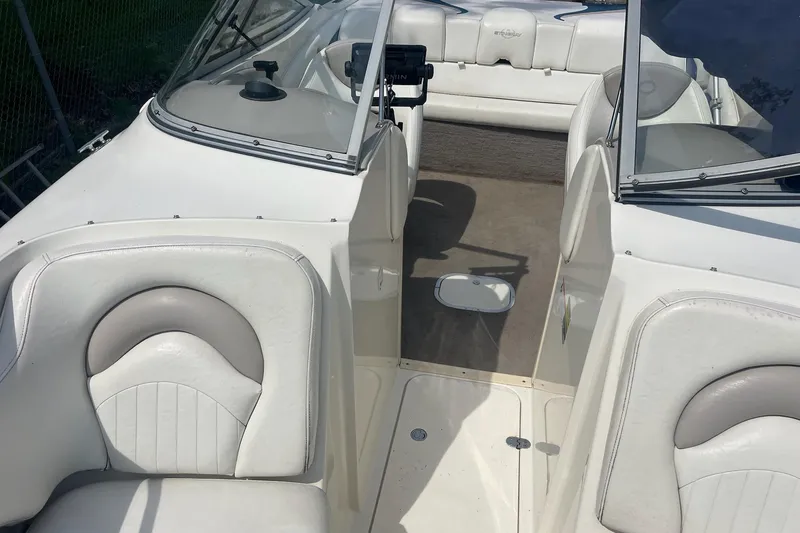 Slide: The Image of Interior view of a 2006 Stingray 230 LX boat with white seating and dashboard. - 9