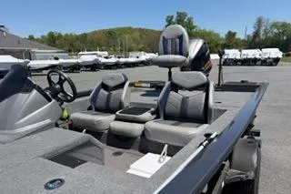 Slide: The Image of 2021 G3 Sportsman 1810 boat with seating, steering wheel, and motor in a parking lot. - 11